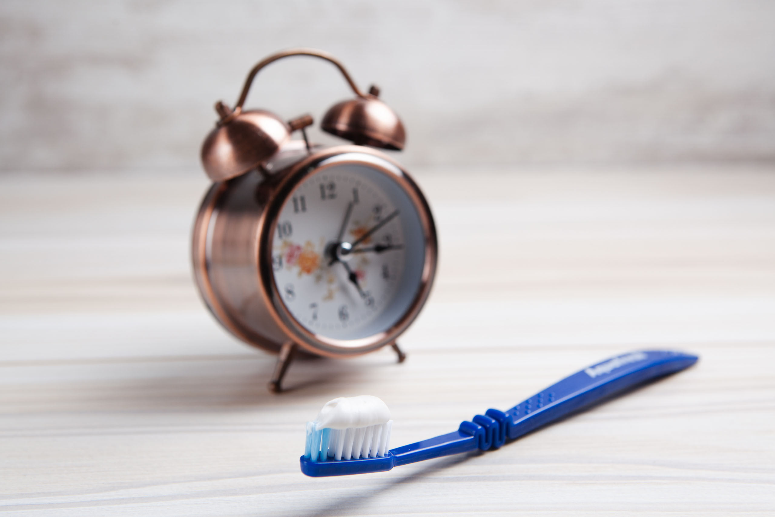 A photo of a toothbrush and a clock