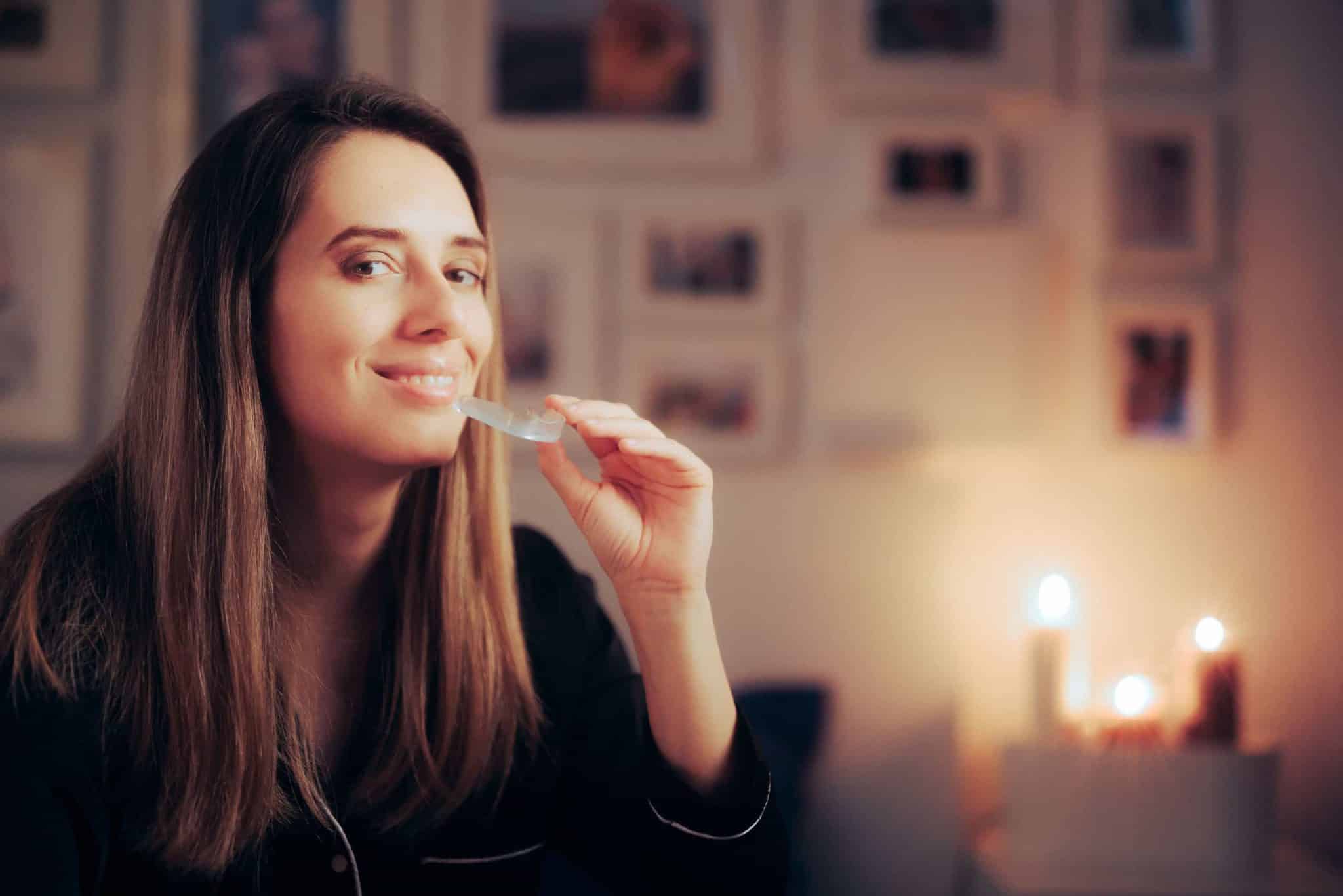 A picture of a woman holding an anti-tooth grinding mouthguard