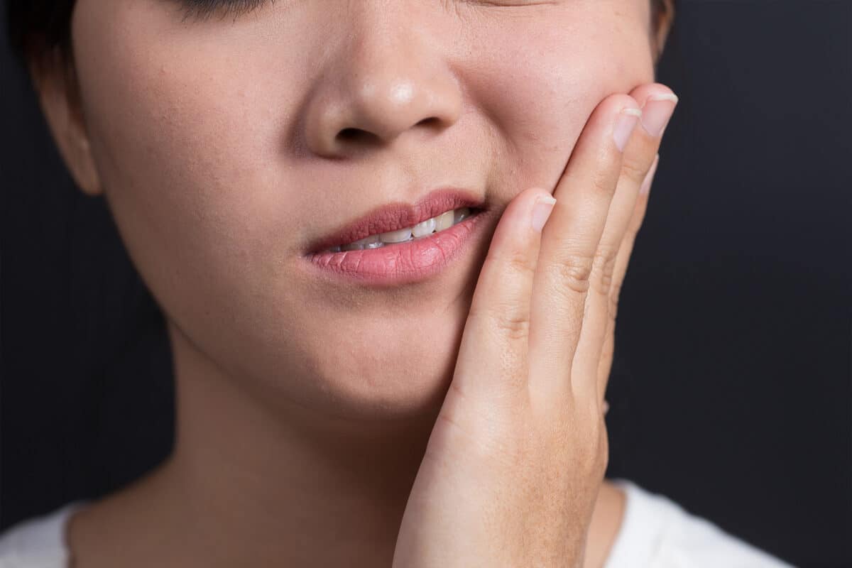 A woman with a swollen cheek and tooth pain.